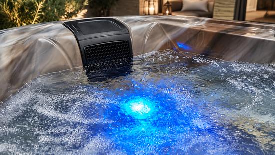 Blue LED lighting glowing through the water at the base of the spa shell