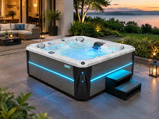 Wide-angle evening view of a hot tub with blue LED lighting on a stone patio