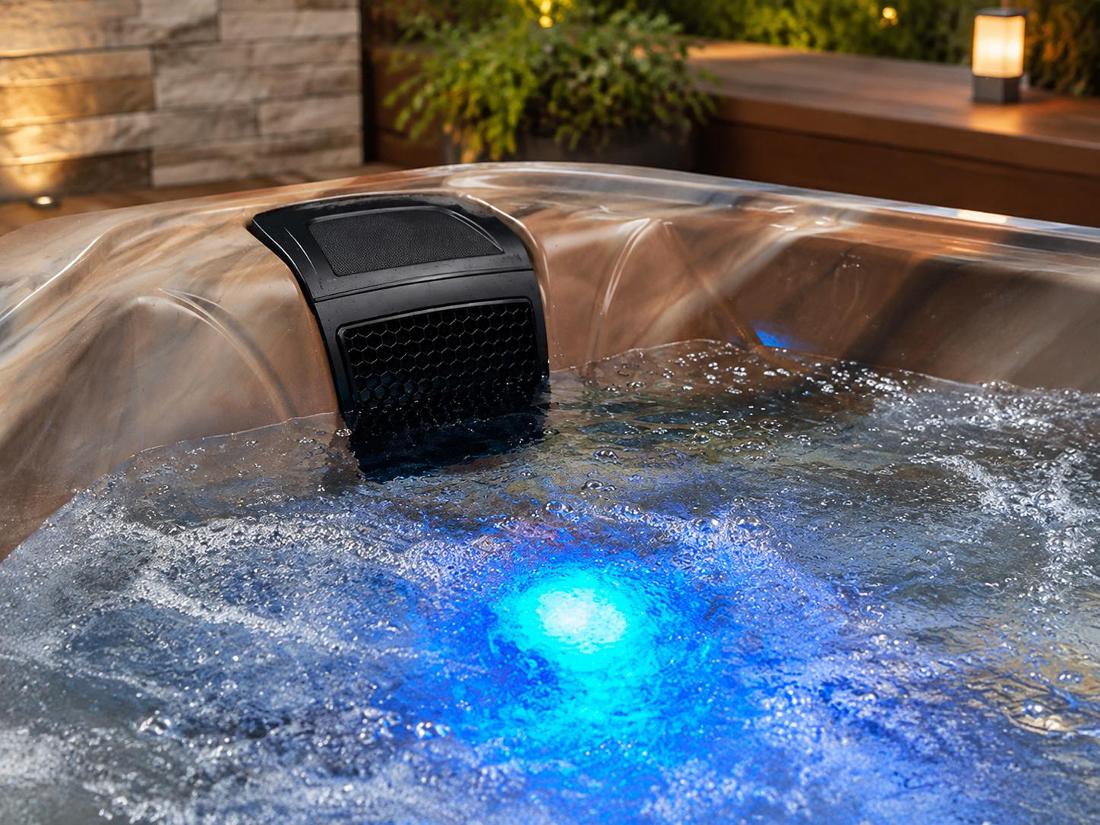 Conceptual detail shot focusing on blue LED lighting at the bottom of the tub casting a soft glow through water