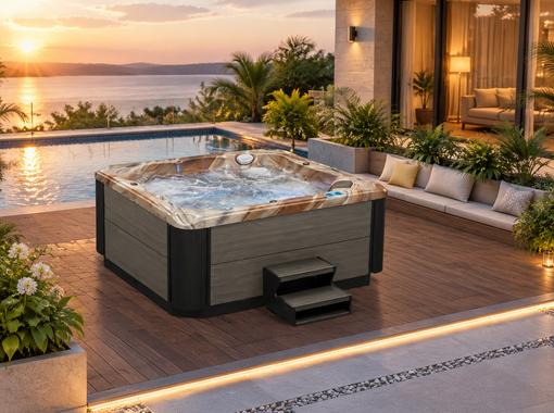 The hot tub installed on a wooden deck surrounded by greenery in a villa backyard
