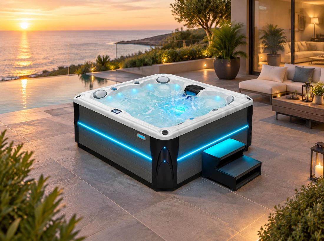 Hot tub illuminated with blue LED lighting on a stone patio at night